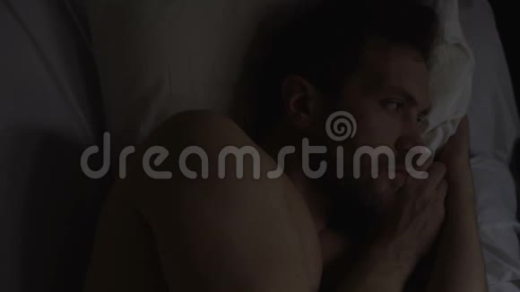 孤独的悲伤的男人失眠躺在床上思考问题视频的预览图