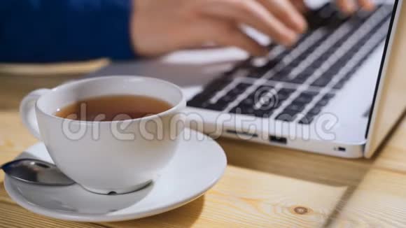 女性手在笔记本电脑上打字喝咖啡键盘打字手视频的预览图