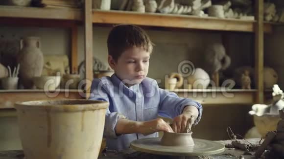 可爱好奇的孩子正在专业车间用旋转投掷轮制作陶罐陶瓷花瓶手工壶视频的预览图