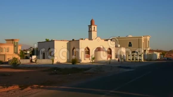 中东一个居民区的白色清真寺在傍晚的阳光下天空蔚蓝视频的预览图