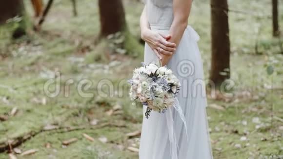 新娘的婚礼花束矗立在松林的苔藓上视频的预览图