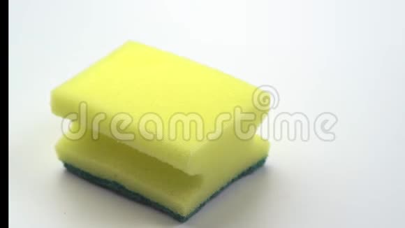 4K超宏关闭盘用黄色海绵的镜头并在白色背景上以绿色凝胶的形式倒入洗涤剂视频的预览图