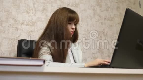 漂亮的女孩坐在办公室的椅子上在电脑上打字说话年轻女商人工作视频的预览图