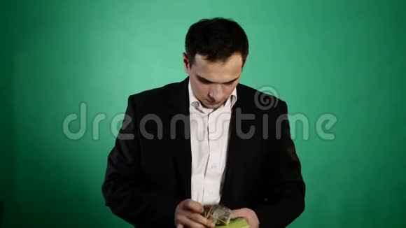 一个年轻人在书中找到钱绿色背景视频的预览图