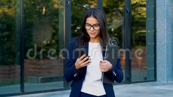 有智能手机的女商人学生女孩用手机戴眼镜的美女在手机上上网视频的预览图