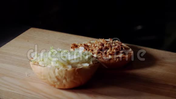 厨师做汉堡在烤架上煎包子放腌黄瓜片视频的预览图
