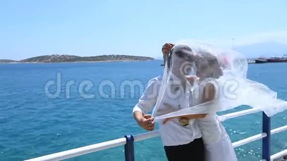 结婚纪念日新婚快乐戴着新娘的面纱在海上海岸视频的预览图