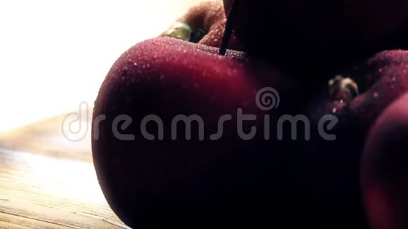 潮湿的熟红苹果放在木桌上视频的预览图