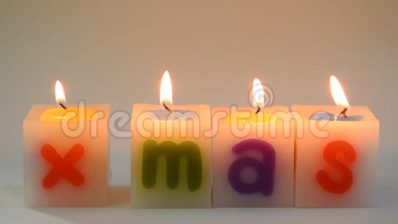 蜡烛在白色背景上排列XMAS单词并熄灭视频的预览图