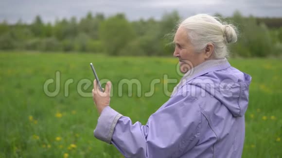 头发灰白的成年女人笑着看着电话视频的预览图