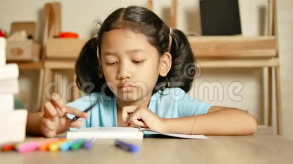 小女孩在做作业微笑着思考着什么视频的预览图
