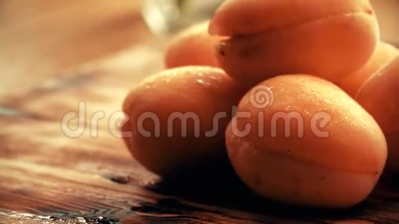 木制桌子上湿熟的杏子视频的预览图