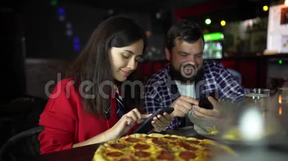 酒吧里的女孩在你的智能手机上拍披萨视频的预览图