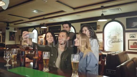 一群朋友正在nice酒吧通过智能手机自拍穿着便装的美女们摆姿势视频的预览图