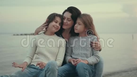 妈妈花时间陪孩子海边的家庭肖像视频的预览图