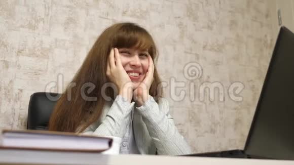 开朗的商务女性坐在黑色的皮椅上在工作场所的餐桌上谈笑风生唱着歌开心快乐视频的预览图
