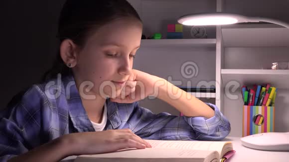 夜晚的孩子阅读黑暗的学校女孩孩子学习家庭作业视频的预览图