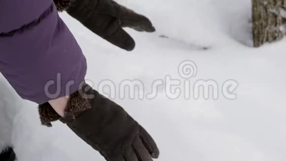 双手合拢戴上温暖的冬天手套拿起一把新鲜的蓬松的雪视频的预览图