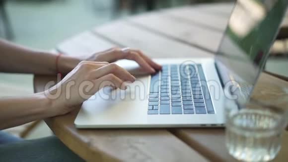 使用触摸板和在户外打字的年轻女人的手视频的预览图