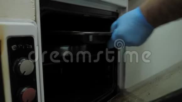 近景厨师手拿黑色烤纸从烤箱视频的预览图