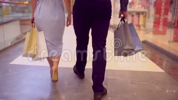 带着女人的男人在商场里拿着包裹购物中心买家手中的大彩包夫妻视频的预览图