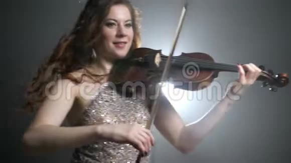 旋律独奏穿着华丽衣服的女人在明亮的灯光下演奏弦乐器视频的预览图