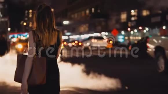 傍晚美国纽约市中心站在交通道路上的年轻美女的后景视频的预览图