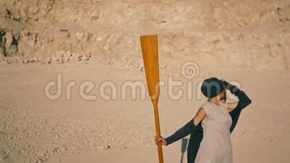 瘦小的女人用桨划着山超现实的场景视频的预览图
