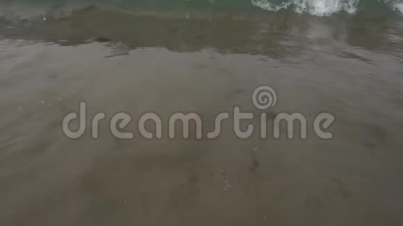 在阳光明媚的一天海滩上的泡沫海波慢动作视频的预览图