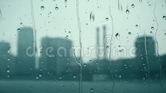 雨点顺着窗户滚下映衬着模糊的城市视频的预览图