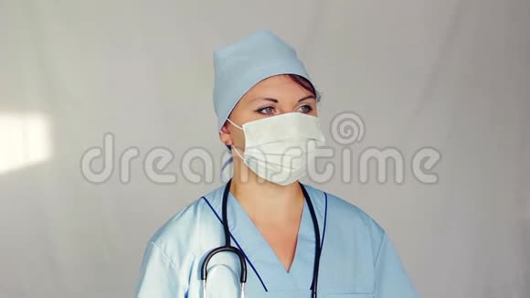 一位戴着面罩的女医生看着他相机从左到右移动视频的预览图