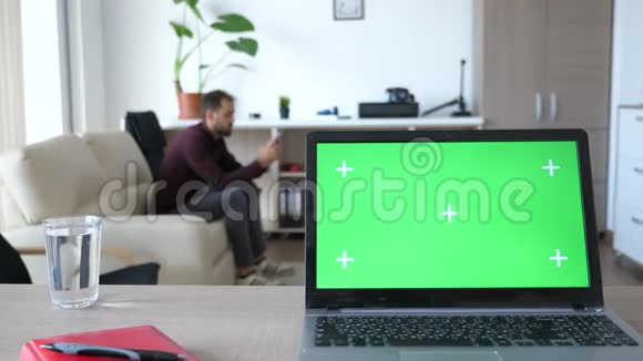 客厅中间带有绿色屏幕色度的笔记本电脑视频的预览图