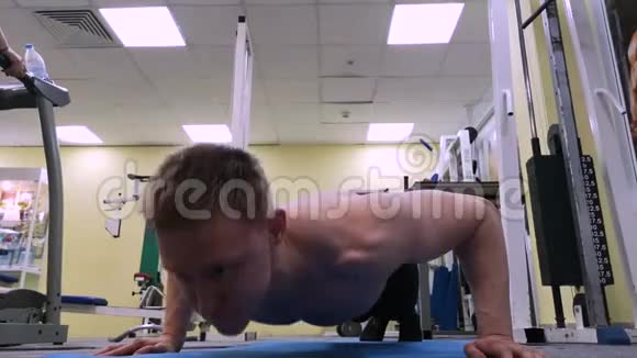 年轻的运动员在健身房做俯卧撑这位运动员从事健身活动视频的预览图