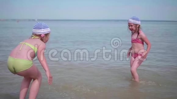 两个小女孩在海上玩耍幼儿倒水创编喷雾炎炎夏日心情开朗视频的预览图