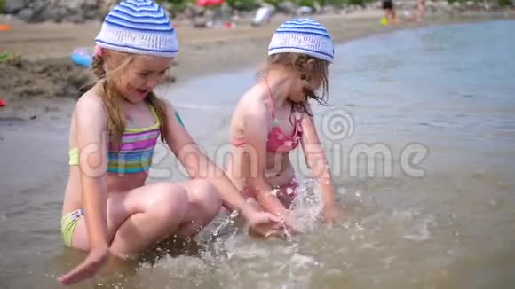 两个小女孩在海上玩耍幼儿倒水创编喷雾炎炎夏日心情开朗视频的预览图