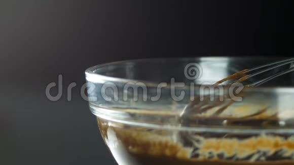 玻璃容器里的液体巧克力花冠从玻璃容器上方升起石质在一个小的地方流动视频的预览图