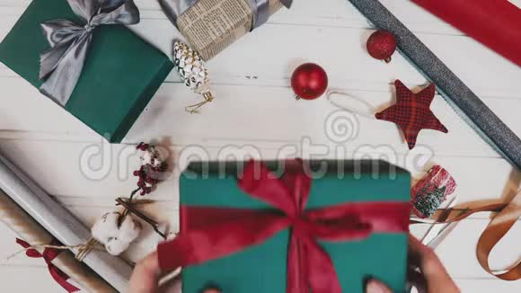 圣诞礼物赠送有些人手拿红色针织毛衣在红色盒子上做蝴蝶结带礼物横幅带复印空间视频的预览图