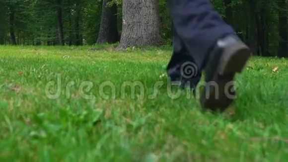 穿商务服的男人把公文包放在草地上走开自由视频的预览图