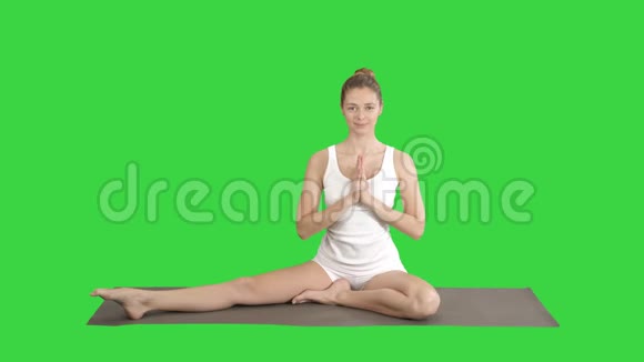 美丽的年轻女子穿着白色的衣服做瑜伽运动坐在一只被缠着的鸽子国王的单只鸽子海视频的预览图