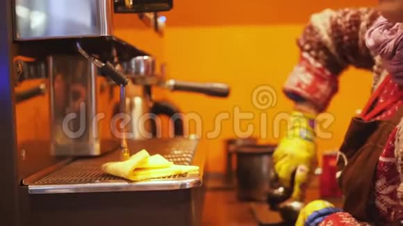 女咖啡师她的双手戴着黄色手套用现代化的咖啡机在咖啡馆的厨房里慢动作煮咖啡视频的预览图