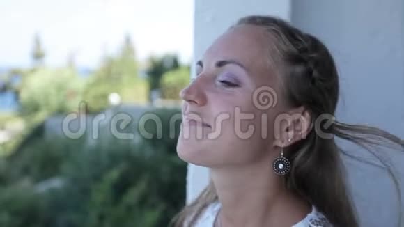 快乐快乐的女孩在海滨酒店的阳台上吸入大海的气味希腊视频的预览图