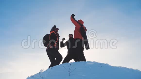 团队合作的赢家团队游客徒步旅行者成功赢得冬天到达山顶剪影阳光视频的预览图