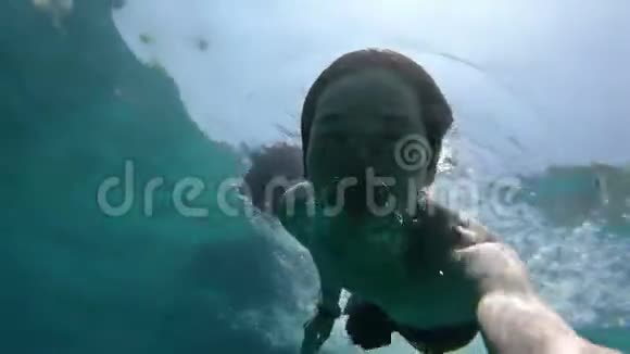 年轻的亚裔男子在海底游泳视频的预览图