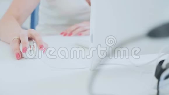 女性在办公桌上用电脑鼠标女性在桌面电脑上工作视频的预览图