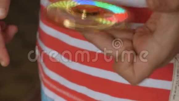 旋转玩具旋转器在一个金发男孩的手中视频的预览图