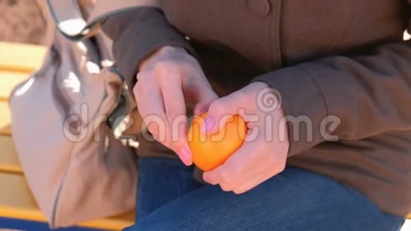 贴身女人她的手在公园里剥橘子视频的预览图