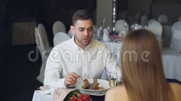 年轻夫妇在餐馆吃饭时吵架大喊大叫打手势玫瑰花束香槟视频的预览图