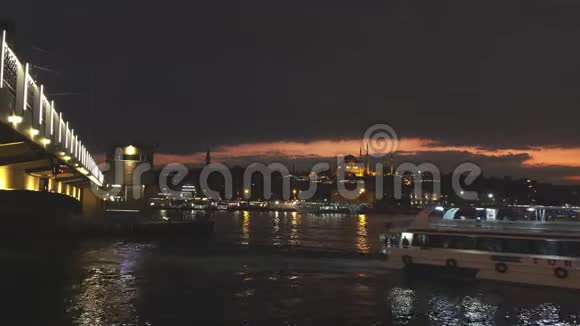 全景伊斯坦布尔城市景观与Suleymaniye清真寺与旅游船漂浮在博斯普鲁斯夜间视频的预览图