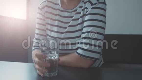 女人用杯水的手特写视频的预览图