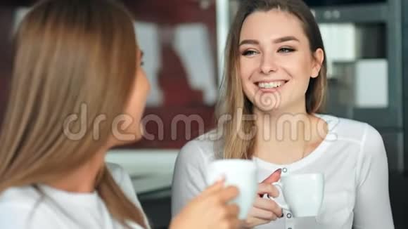 两个女朋友在厨房里喝咖啡聊天玩得开心视频的预览图